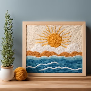 May include: A framed wall art piece with a yarn-based depiction of a sunset over the ocean. The sun is yellow, the clouds are white, and the ocean is blue with white waves.
