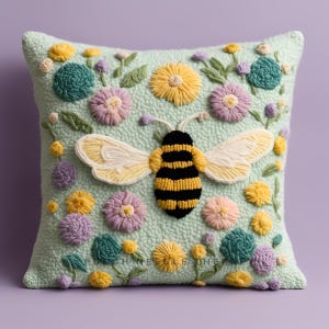 May include: A green throw pillow with a bee and flowers embroidered on it. The bee is yellow and black, and the flowers are pink, purple, and yellow.