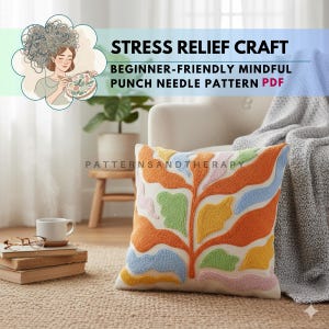 Könnte beinhalten: Ein dekoratives Kissen mit einem farbenfrohen, abstrakten Blattdesign. Das Kissen zeigt orange, gelbe, blaue, grüne und rosa Stickereidetails auf cremefarbenem Hintergrund. Der Text "Stress Relief Craft" und "Beginner-Friendly Mindful Punch Needle Pattern PDF" ist ebenfalls zu sehen.