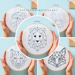 May include: Five embroidery hoops with geometric animal designs. The designs include a lion, eagle, fox, wolf, and bear. The designs are all black and white.