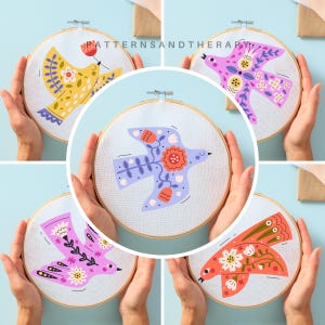 May include: Four embroidery hoops with different floral bird designs. The birds are in various colors, including pink, blue, yellow, and orange. Each hoop has a white background and a wooden frame.