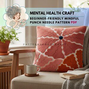Könnte beinhalten: Ein dekoratives korallenfarbenes Kissen mit floralem Design, weißen Akzenten und einem marineblauen Mittelknopf. Das Kissen liegt auf einem Stuhl mit einer Tasse Kaffee und dem Text "MENTAL HEALTH CRAFT BEGINNER-FRIENDLY MINDFUL PUNCH NEEDLE PATTERN PDF".