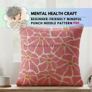 Könnte beinhalten: Ein quadratisches, rosa Kissen mit Blumenmuster, gelben Zentren und weißen Konturen. Das Kissen liegt auf einer Holzoberfläche. Oben steht der Text "MENTAL HEALTH CRAFT" und "BEGINNER-FRIENDLY MINDFUL PUNCH NEEDLE PATTERN PDF".