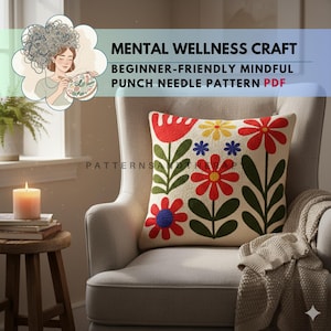 Könnte beinhalten: Ein dekoratives Kissen mit einem Blumenmuster in Rot, Gelb, Blau und Grün liegt auf einem beigen Sessel. Das Kissen hat ein Punch-Needle-Muster. Über dem Kissen steht der Text "MENTAL WELLNESS CRAFT BEGINNER-FRIENDLY MINDFUL PUNCH NEEDLE PATTERN PDF."