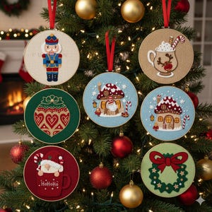 May include: A collection of embroidered Christmas ornaments hanging on a decorated tree. The ornaments feature various festive designs, including a nutcracker, a hot cocoa mug, a gnome, and a wreath. Each ornament is round with a red ribbon for hanging.