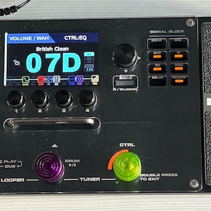 Puede incluir: Un pedal de efectos múltiples NUX MG-30 negro con una pantalla digital que muestra "British Clean 07D". El pedal tiene una variedad de perillas, botones e interruptores de pedal, que incluyen una perilla de volumen maestro, un pedal de wah, una perilla de control, un afinador, un looper y una caja de ritmos.