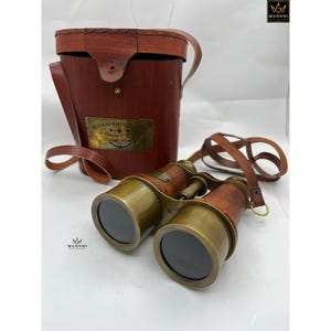 Peut inclure: Jumelles de style vintage avec une sangle en cuir et un boîtier en bois, ainsi qu'un étui en bois assorti. Les jumelles ont des accents en laiton et une étiquette indiquant "Victorian Marine Telescope".