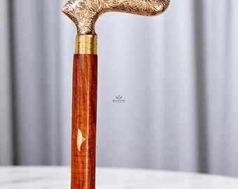 May include: A wooden walking cane with a brass handle. The handle is intricately carved with a floral design. The shaft is a rich brown color with a decorative inlay. The cane is a stylish accessory.