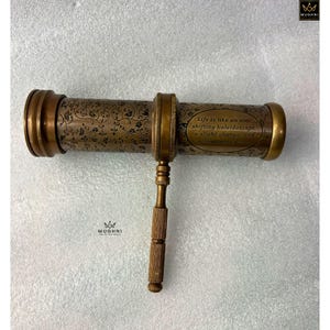 May include: Antique brass kaleidoscope with floral engravings and the quote "Life is like an ever shifting kaleidoscope a slight change, and all patterns alter." The handle and end pieces are a lighter brass color.