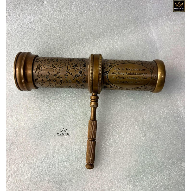 May include: Antique brass kaleidoscope with floral engravings and the quote "Life is like an ever shifting kaleidoscope a slight change, and all patterns alter." The handle and end pieces are a lighter brass color.