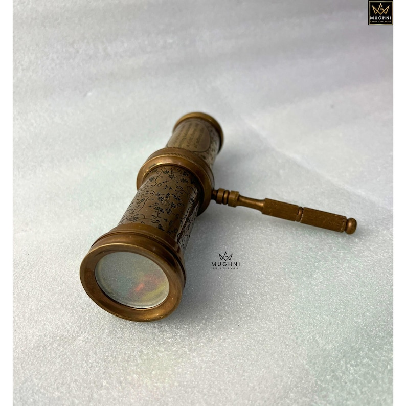 May include: A vintage brass telescope with intricate floral engravings. The telescope features a handle and lens, showcasing a classic design. The image is set against a neutral background, highlighting the antique aesthetic.