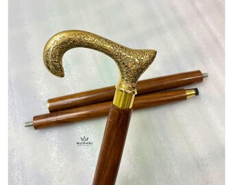 May include: A wooden walking cane with a brass handle featuring an ornate floral design. The cane has a dark brown wooden shaft and a gold-colored brass handle. The cane is shown disassembled with two additional wooden sections.