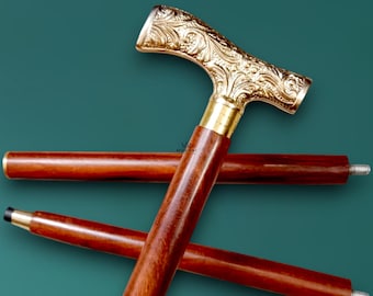 May include: A decorative walking cane with a gold-colored, ornate handle and a dark brown wooden shaft. The handle features an intricate floral design. The cane is approximately 36 inches long.