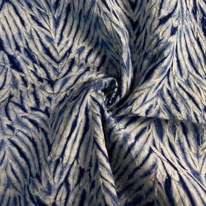 Op de afbeelding: Blauw en wit stof met een chevron-patroon. De stof is zacht en heeft een licht getextureerd oppervlak.