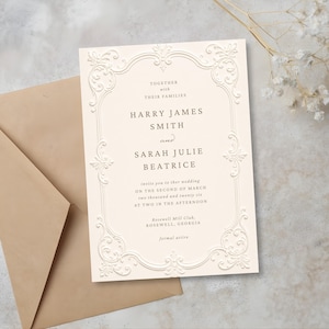 Peut inclure: Faire-part de mariage ivoire avec cadre floral en relief et texte. L'invitation comprend les noms Harry James Smith et Sarah Julie Beatrice, ainsi que les détails de l'événement. Une enveloppe marron est visible.