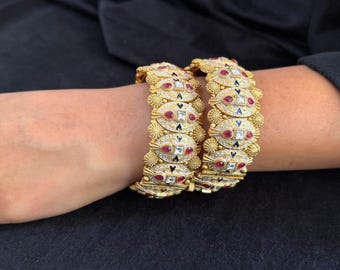 Ruby & Meenakari Wedding Kada - Bridal bangles in matte gold featuring pear-cut rubies, meenakari detailing, and square stone insets.