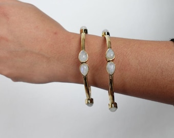 Teardrop Moonstone Brass Cuff - Sleek gold-tone brass cuff with teardrop moonstones in minimalist design.