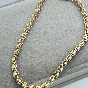 Close up side view of a gold tennis bracelet with round clear Moissanite stones