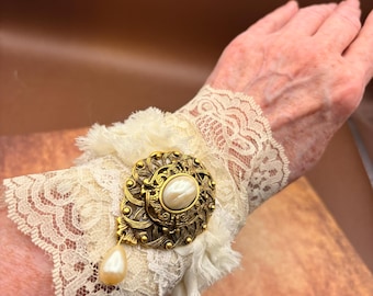 Cuff Bracelet, with White Lace and white trim, a 70's vintage brooch is the focal