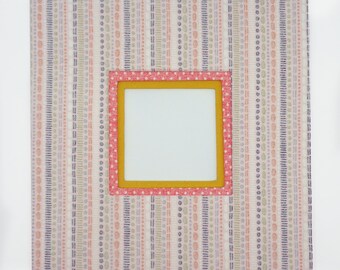 May include: A white frame with a pink and yellow border, featuring a patterned background with vertical stripes and small circles. The frame is empty.