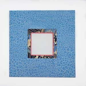 May include: A blue card with a crackled texture and a decorative frame with a white center. The frame has a floral pattern in shades of blue, gold, and pink.