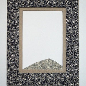 May include: Rectangular picture frame with a navy blue paisley pattern border. The frame has a neutral-colored interior border and a white background. The frame is designed to hold a photograph or artwork.