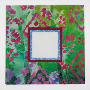May include: A square frame with a white background and a blue and red border. The frame is set against a green and pink background with a mottled pattern.