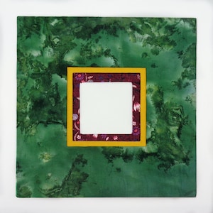 May include: A green fabric picture frame with a smaller inner frame. The inner frame is burgundy with a yellow border and a white background.