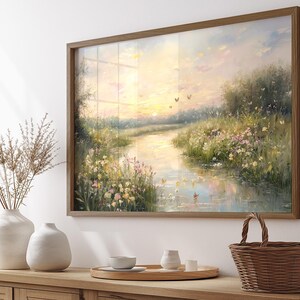 May include: A framed painting of a peaceful river scene with a sunset in the background. The river is surrounded by lush green grass and wildflowers. Butterflies fly in the sky above the river.