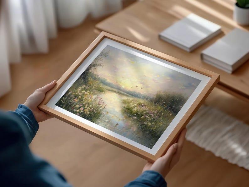 May include: A framed painting of a landscape with a river flowing through a field of wildflowers. The sky is a soft pink and blue, and there are a few birds flying overhead.