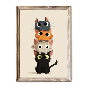 May include: A framed print featuring a stack of four cartoon cats. The cats are in various colors: black, orange, gray, and dark gray. The cats have large eyes and are stacked on top of each other. The background is a light beige color.