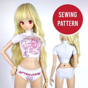 Può includere: Top bianco corto a maniche corte con una grafica di drago rosa. Il top ha un collo alto e il testo "龙" sul davanti. Biancheria intima bianca con una grafica rosa "AFTER DARK" e un design a teschio.