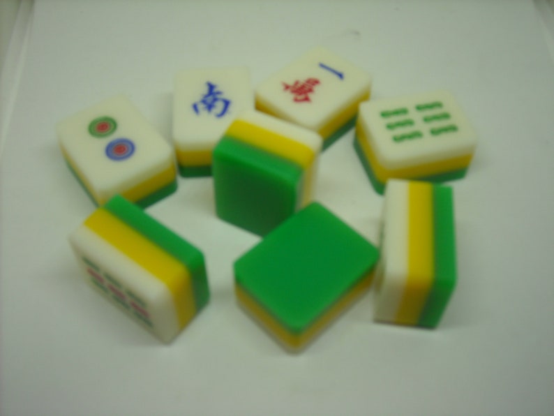 May include: A set of eight green, yellow, and white mahjong tiles. The tiles have Chinese characters and symbols on them.