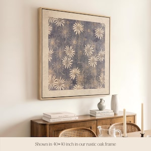 May include: A framed artwork with a blue and beige floral pattern. The artwork is displayed in a rustic oak frame, measuring 40 x 40 inches. The image shows the artwork above a wooden cabinet with books and decorative items.