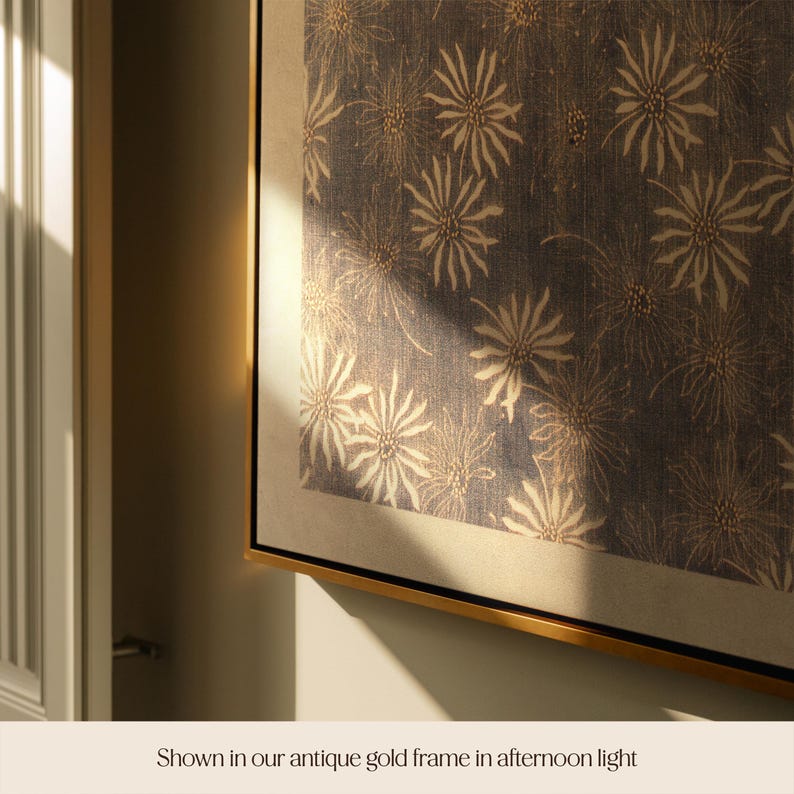 May include: A framed artwork featuring a repeating floral pattern in cream and gold on a dark blue background. The artwork is displayed in a gold frame, creating a sophisticated and elegant aesthetic. The image is well-lit, highlighting the details of the design.