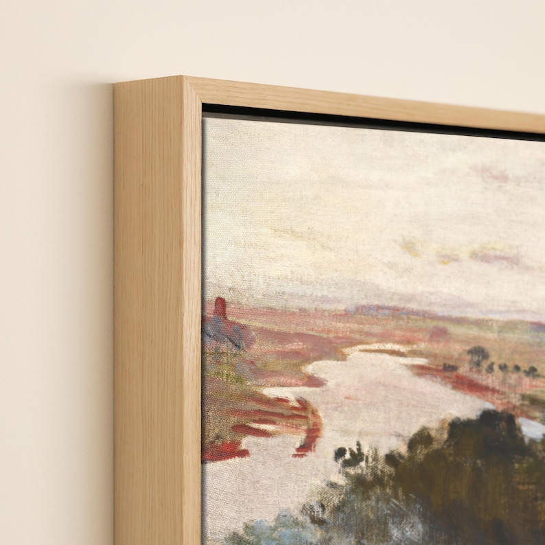 May include: A framed landscape painting depicting a river scene under a pale sky. The artwork is presented in a natural wood frame. The painting's colour palette includes muted tones of red, brown, and green. The frame adds a touch of rustic elegance.