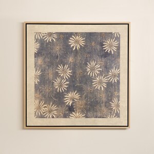 May include: Square framed artwork featuring a blue background with a repeating pattern of white, starburst-like floral designs. The artwork is framed in a light-colored wooden frame with a neutral-toned border.