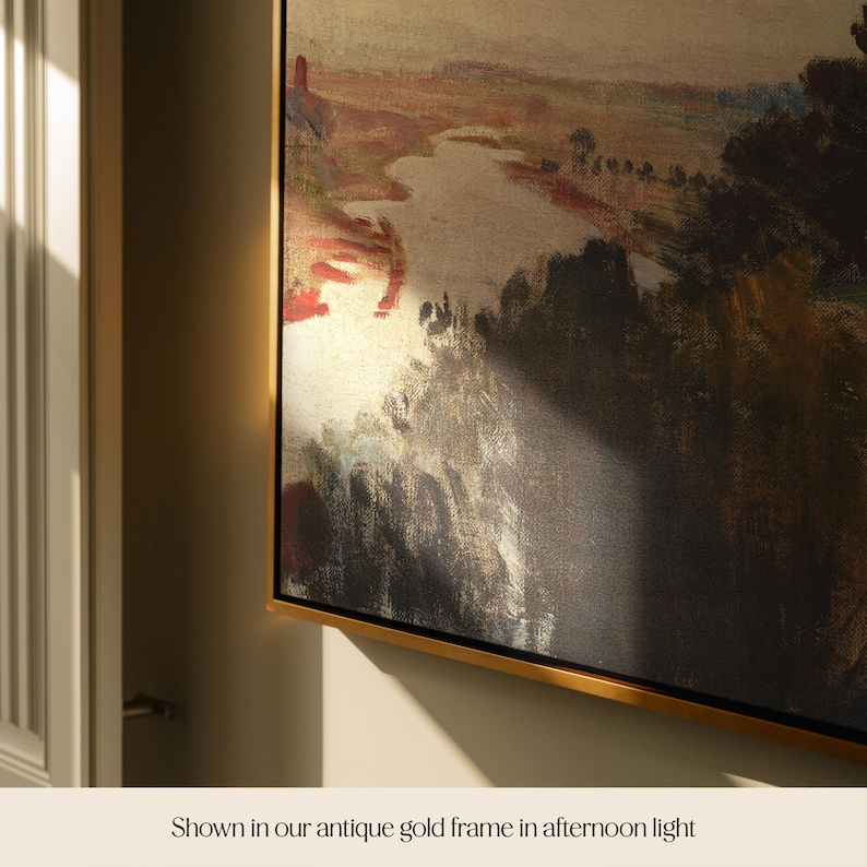 May include: A landscape painting in an antique gold frame. The artwork depicts a river and trees, with a palette of browns, reds, and golds. The text at the bottom reads "Shown in our antique gold frame in afternoon light."