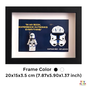 Könnte beinhalten: Schwarzer Rahmen mit einem Lego Captain Rex-Figur und Helm-Design auf marineblauem Hintergrund. Der Rahmen enthält den Text "IN MY BOOK, EXPERIENCE OUTRANKS EVERYTHING." und "CAPTAIN REX - 501 LEGION". Der Rahmen misst 20x15x3,5 cm.