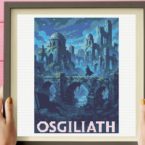 May include: A framed cross-stitch pattern depicting a dark blue, pixelated landscape of ruined stone structures and a bridge under a starry night sky, with the word OSGILIATH printed in large, light-colored capital letters at the bottom.