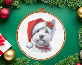 May include: A cross stitch pattern featuring a white West Highland White Terrier dog wearing a red Santa hat with a white pom-pom, a red collar with a small bell, and a red poinsettia flower on its ear, all displayed in a round wooden hoop.
