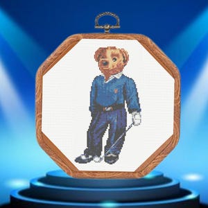 May include: A brown teddy bear wearing a blue polo shirt and holding a golf club. The bear is framed in a wooden octagon.