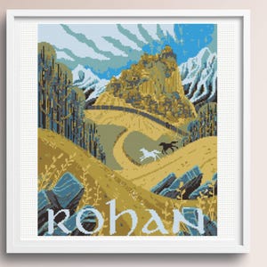 May include: A framed cross-stitch embroidery depicting a landscape with a golden hill, a fortress, snow-capped mountains, and two horses running on a path. The word ROHAN is stitched in large, light-colored letters at the bottom of the design.