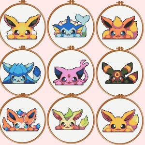 May include: Nine circular wooden embroidery hoops containing cross-stitch patterns of various pixelated creatures. Each hoop features a different colourful character on white fabric, including yellow, blue, orange, pink, and green designs.