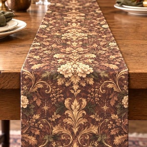 May include: A long rectangular table runner featuring a dark brown background with a repeating damask pattern in shades of cream, tan, and muted green. The intricate design includes stylized floral motifs, scrolling acanthus leaves, and small star shapes.