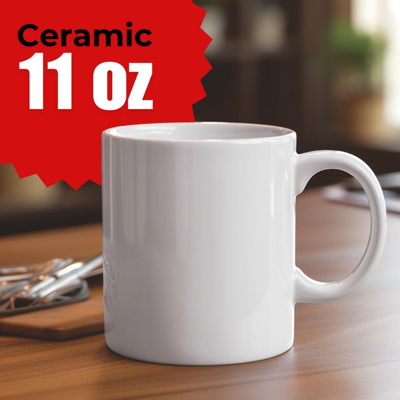 May include: A white ceramic mug with a curved handle. The mug has a capacity of approximately 325 ml. The word "Ceramic" is printed above the capacity in white text on a red background. The mug is on a wooden surface.
