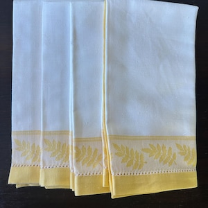 May include: Set of five white linen tea towels with a yellow border and a yellow leaf design.