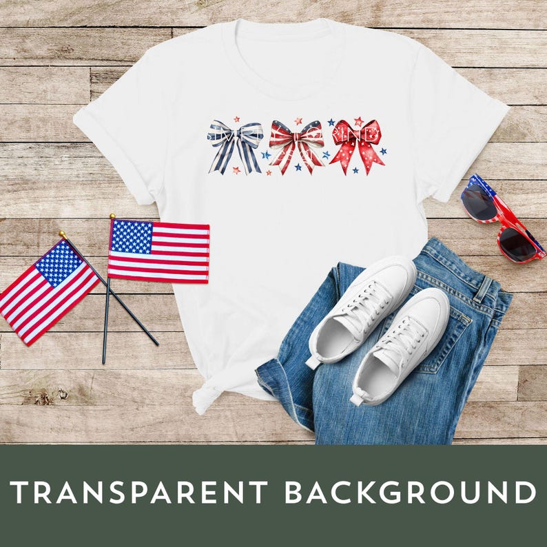 K&ouml;nnte beinhalten: Wei&szlig;es T-Shirt mit drei roten, wei&szlig;en und blauen Schleifen. Die Schleifen sind horizontal in der Mitte des Shirts angeordnet. Das Shirt liegt auf einer Holzoberfl&auml;che mit zwei amerikanischen Flaggen und einem Paar wei&szlig;en Sneakers.