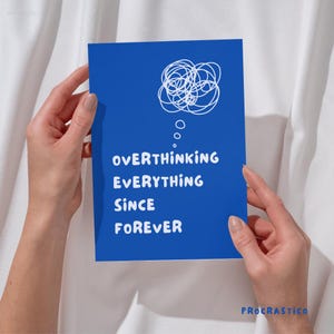 Puede incluir: Tarjeta azul con texto blanco que dice "Overthinking Everything Since Forever" con un garabato blanco de una burbuja de pensamiento sobre el texto. La tarjeta está sostenida por una mano.