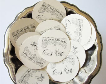 May include: A silver bowl filled with round white paper gift tags with black ink. Each tag has a black and white illustration of a bear and a pig with the text "Christmas Greetings" printed on each tag.